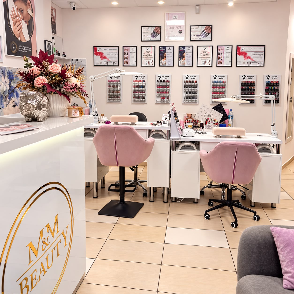 Recepcja ze złotym logo M&M Beauty i stanowiska do stylizacji paznokci